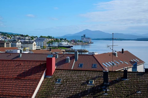 City view with red roofs of Molde, fjord landscape, sea, mountains in the background and blue,