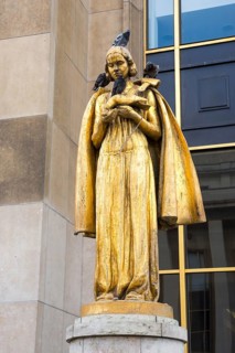 Golden statue Les Oiseaux (a woman feeding pigeons) by Louis Brasseur, street pigeons (Columba
