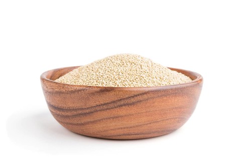 Wooden bowl with raw white quinoa seeds isolated on white background. Side view, close up