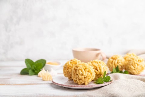 Traditional Tatar candy chak-chak made of dough and honey with cup of coffee on a white wooden
