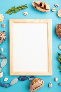 Composition with wooden frame, seashells, green boxwood. mockup on blue pastel background. Blank,