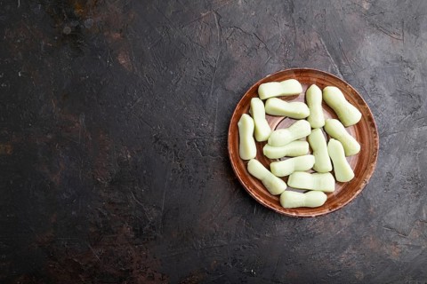 Jelly celery candies on black concrete background. copy space, top view, flat lay, close up