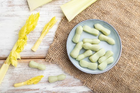 Jelly celery candies on white wooden background and linen textile. close up, top view, flat lay