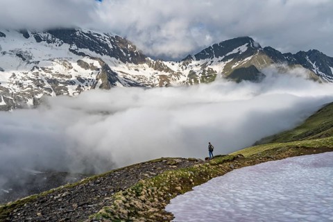 Mountaineer in front of mountain landscape with high fog in the valley, summit Hochfeiler and