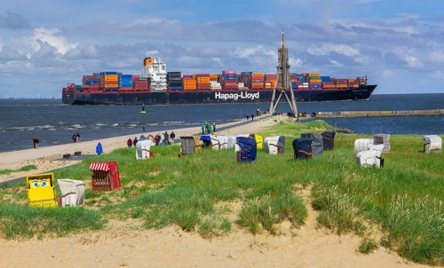 Beach promenade with landmark Kugelbake and container ship in the district of Döse, North Sea spa