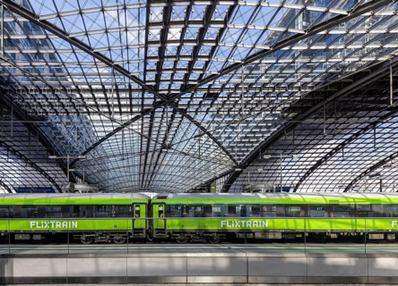 Central station, pillarless glass roof construction above the platforms, green train of the railway