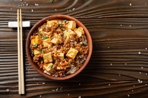 Flat lay view at mapo tofu dish with pork chives steamed rice and soy sauce closeup