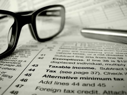 Financial Image Of Some Tax Forms With Glasses And A Pen