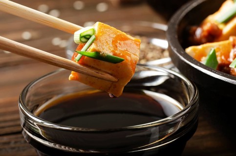 Mapo tofu dish of soybean curd piece being held in chopsticks