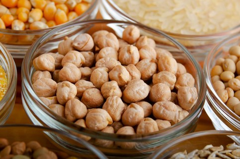 Chickpeas closeup in glass bowl on wooden kitchen table, non-perishable, long shelf life food
