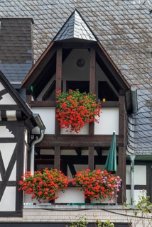Balconies with lots of flowers in a typical half-timbered house with slate roof in Ernst, Landkreis