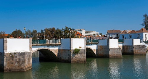 Historic white arch bridge over a quiet river in an urban landscape, Ponte Romana, Roman bridge,