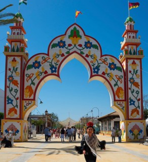 Colourful gate with floral patterns, people in the background, festive atmosphere, Feria de la