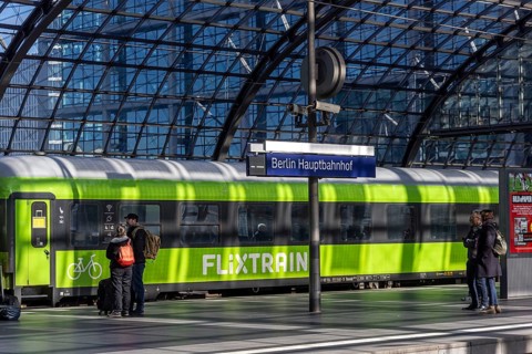 Central station, pillarless glass roof construction above the platforms, station sign and train of