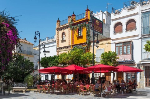 Cosy pavement café with red parasols in a historic square, Plaza del Cabildo, Sanlúcar de