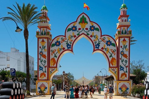 Decorative Tor tor with floral motifs and a crowd of people below, festive ambience, Feria de la