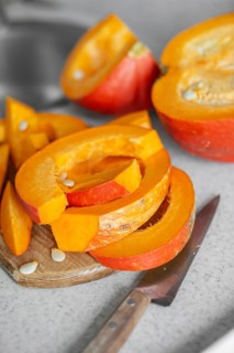 Just cut for meal preparing pumpkin slices on cutting board real photo made at authentic kitchen