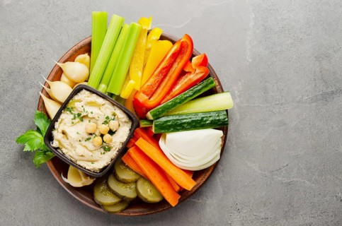Flat lay view at vegetable Hummus dip dish topped with chickpeas and olive oil