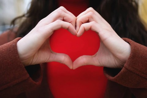 A close-up of a woman making a gesture of love. Valentines day