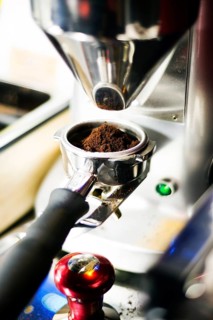 Classic coffee bean grinder detail with ground espresso portion