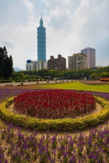 A colorful bed of flowers in the foreground of the Taipei 101 building in downtown Taipei, Taiwan,