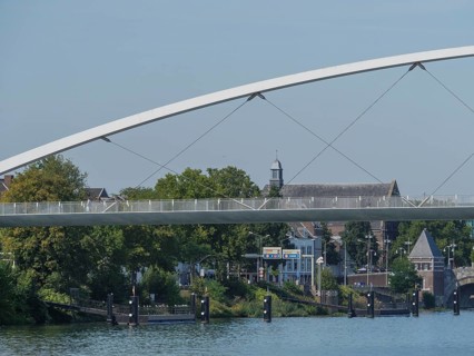 View of a modern bridge and historic buildings along a river in summer, maastricht. netherlands