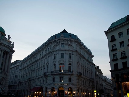 Evening street scene with illuminated facades and charming café on the corner, Vienna, Austria,