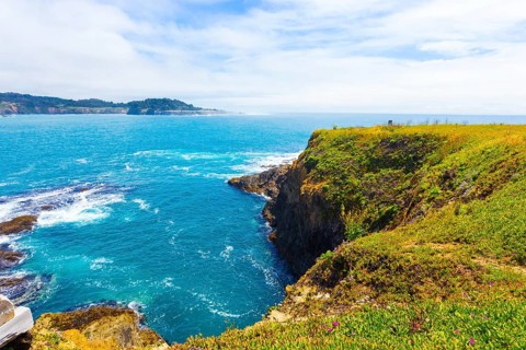 Beautiful rocky coastline and churning ocean below cliffs near Mendocino Bay on sunny day in