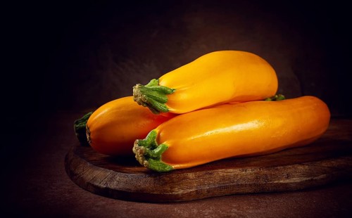 Yellow zucchini, fresh, raw, on a wooden chopping board, no people