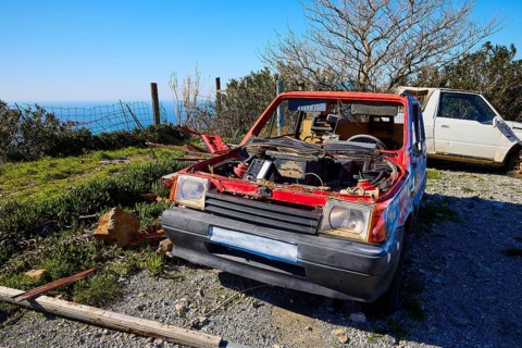 An abandoned, red car without bonnet overlooking the sea, wrecked vehicle, Crete, Greek Islands,