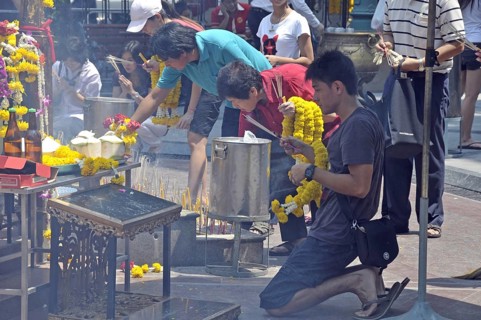 Worshippers with incense sticks at prayer, Erawan Shrine, Bangkok, Thailand, Asia