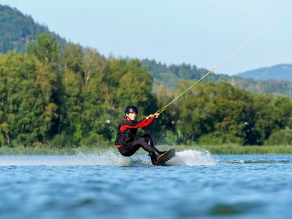 Young man doing sports with wakeboard in lake, water sports, water skiing in wakepark, Stráž pod