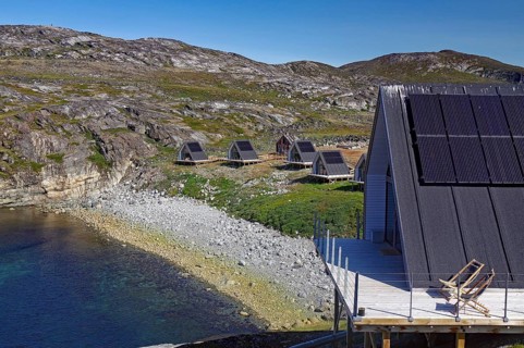 Modern wooden cabins with solar panels on a rocky coastal landscape in nature, Tourimus, Ilimanaq,