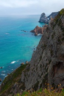 View from a cliff onto the turquoise blue sea and rocky coast, Cape Cabo da Roca, westernmost point