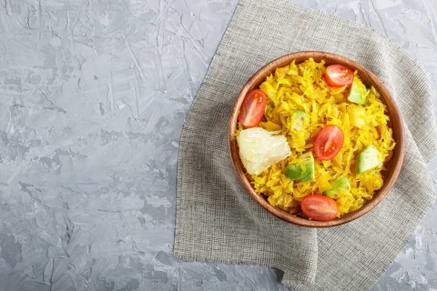 Fried pomelo with tomatoes and avocado in wooden plate on gray concrete background. Top view, copy