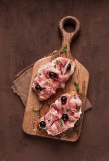 Breakfast, bacon and olives sandwich, on a cutting board, top view, close-up, no people