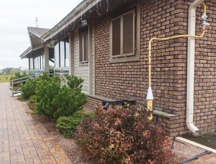 Modern restaurant with green lawn, tile path and landscape design with ornamental grasses and