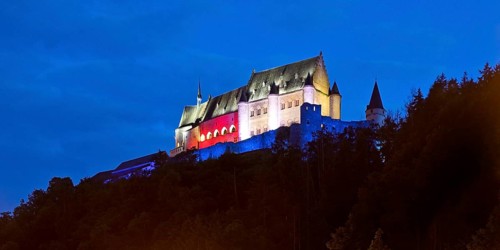 Vianden Castle, hilltop castle illuminated in the colours of the Luxembourg flag for the bank