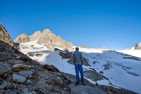 Mountaineer in mountain landscape, rocky summit of Aiguille du Tour and Glacier du Tour in the
