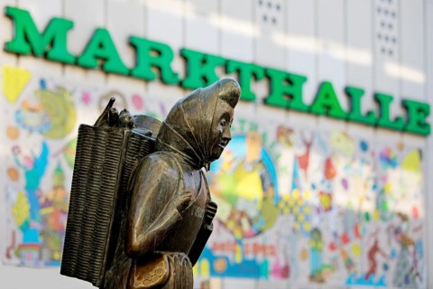 The bronze sculpture Kiepenfrau by Hans-Jürgen Zimmemann shows Karoline Duhnsen in front of the