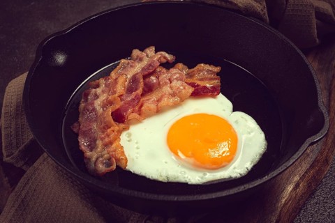 Fried egg with bacon, in a cast-iron pan, breakfast, top view, close-up, homemade, no people