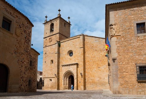 Stone building with bell tower and a person in front of the entrance in daylight, Cathedral,