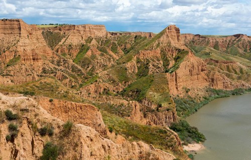 Ein beeindruckender Canyon, der sich entlang eines Flusses erstreckt, mit einer Mischung aus