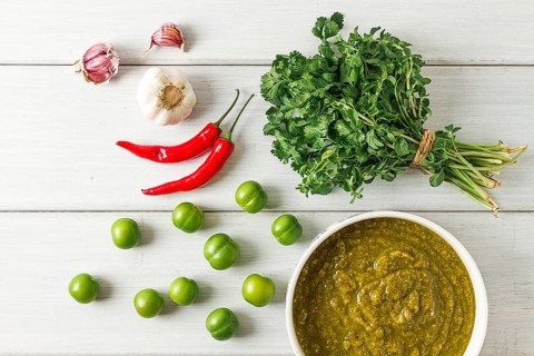 Tkemali sauce, traditional Georgian cuisine, green cherry plum, with ingredients for sauce,