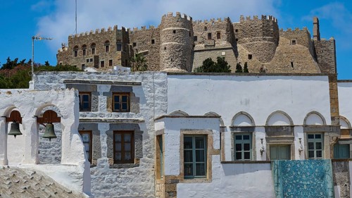 Old castle above traditional white houses with endless blue sky and bright sunshine, St John's