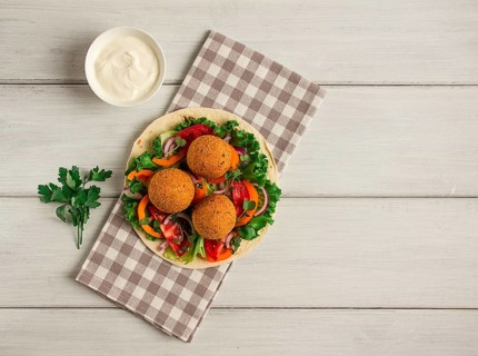 Tortillas, wrapped falafel balls, with fresh vegetables, vegetarian healthy food, on a wooden white