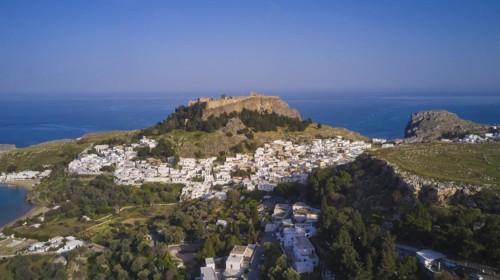 Drone shot, Lindos, Acropolis of Lindos, late afternoon light, coastal town below a ruined castle