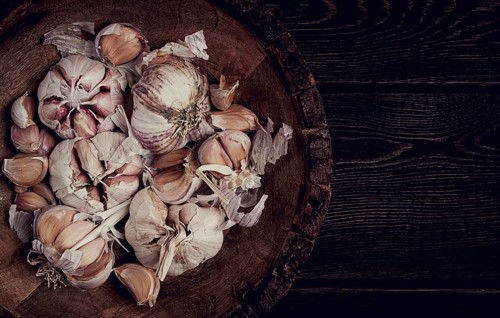Fresh garlic, in a wooden plate, top view, close-up, no people