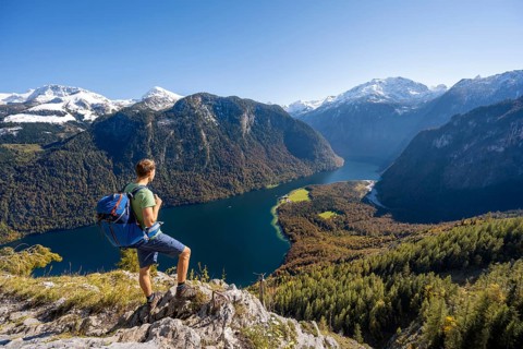 Mountaineer on an exposed mountain hiking trail, Rinnkendlsteig, view of the Königssee, autumnal
