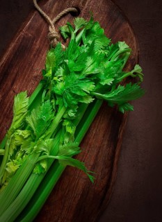Fresh bunch of celery, top view, no people, on a dark background